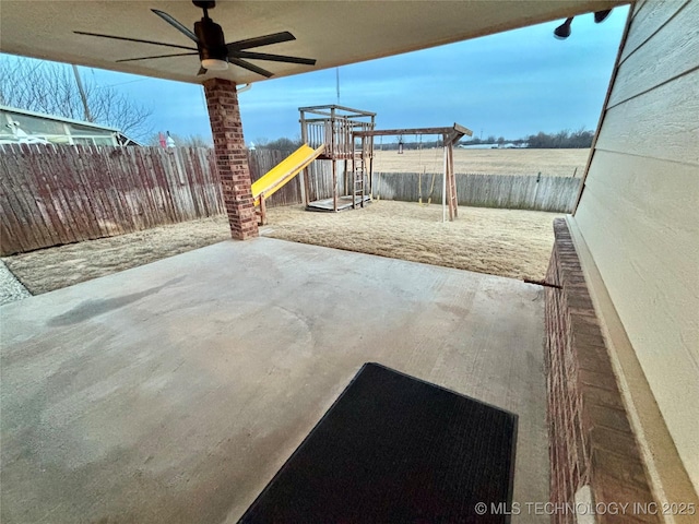 view of patio with a fenced backyard, a ceiling fan, and a playground