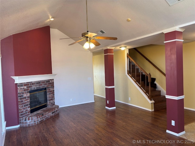 unfurnished living room with a fireplace, lofted ceiling, visible vents, wood finished floors, and stairs