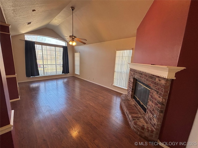 unfurnished living room with lofted ceiling, ceiling fan, a textured ceiling, dark wood-type flooring, and a fireplace