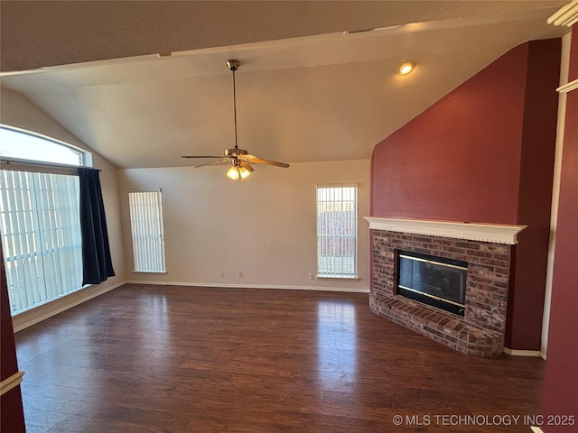 unfurnished living room featuring baseboards, lofted ceiling, ceiling fan, wood finished floors, and a fireplace