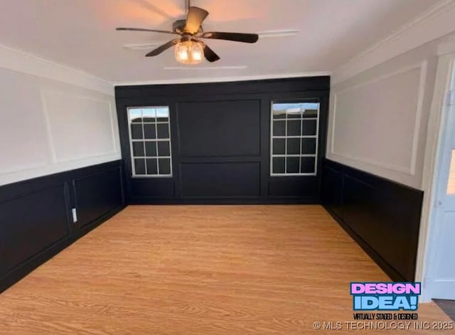 unfurnished room featuring ornamental molding, a decorative wall, light wood-style flooring, and ceiling fan