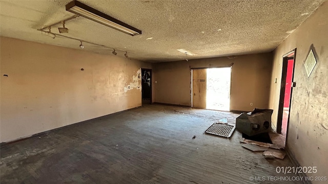 miscellaneous room featuring rail lighting, wood-type flooring, and a textured ceiling