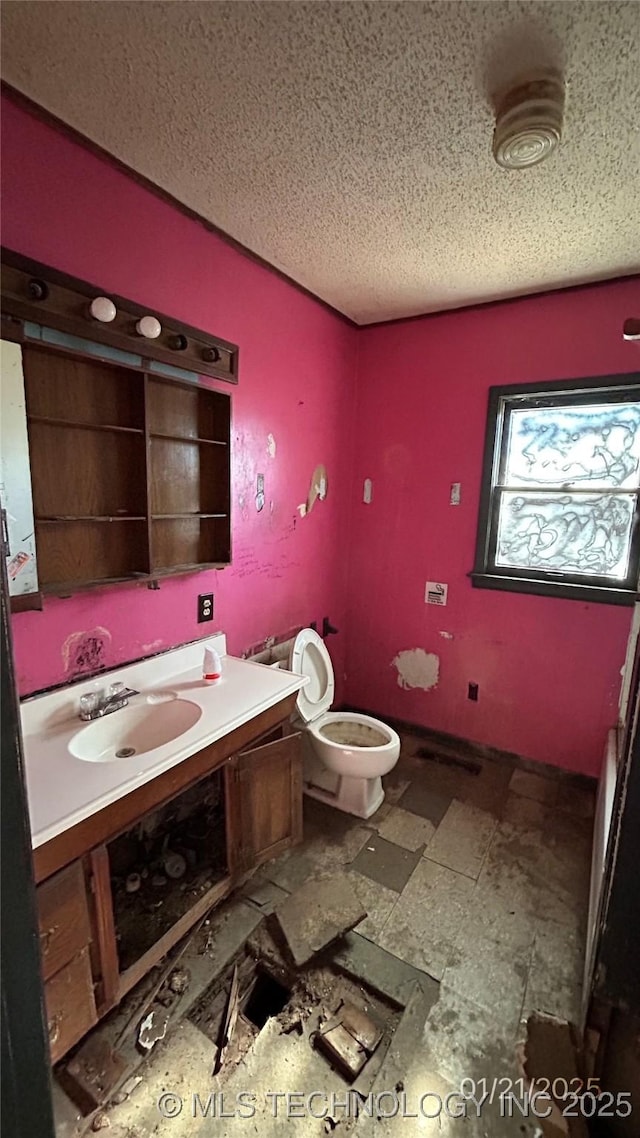 bathroom featuring vanity, toilet, and a textured ceiling