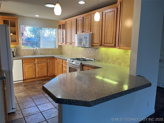 kitchen with a kitchen bar, sink, decorative light fixtures, kitchen peninsula, and white appliances