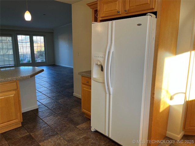 kitchen featuring white refrigerator with ice dispenser and pendant lighting