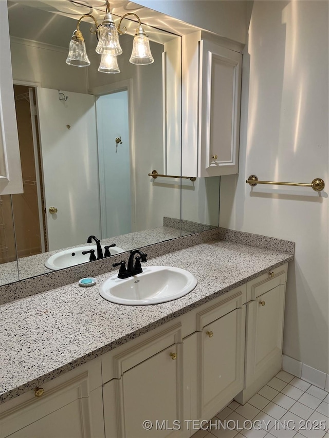 bathroom featuring tile patterned flooring, vanity, and crown molding