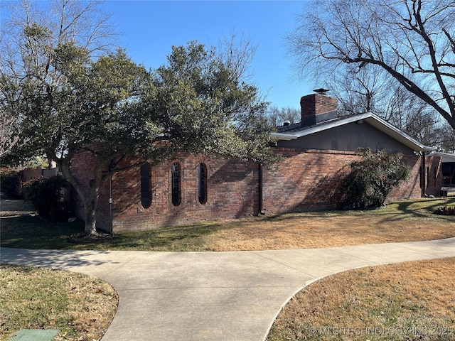 view of side of home with a lawn