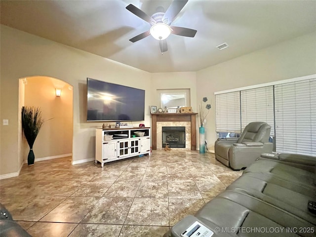 living room featuring a fireplace, tile patterned floors, and ceiling fan