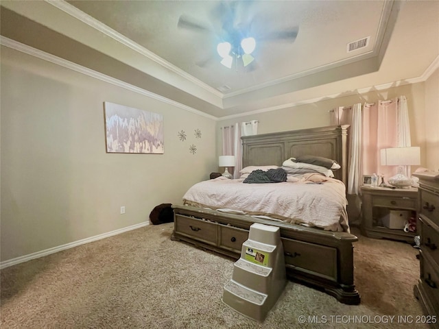 bedroom with a tray ceiling, ornamental molding, ceiling fan, and carpet