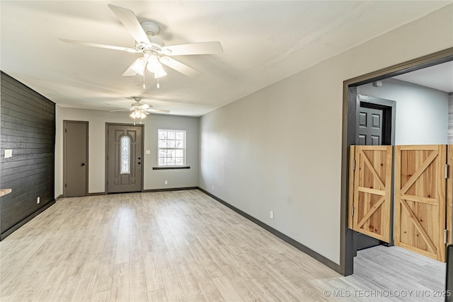 foyer entrance featuring wood walls and light wood-type flooring