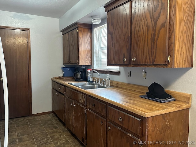 kitchen featuring dark brown cabinetry and sink