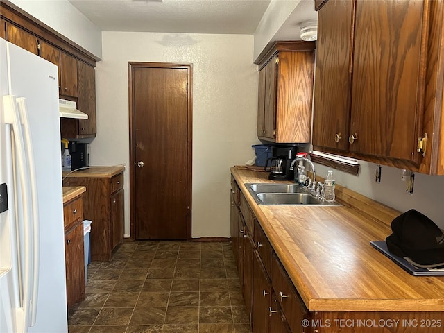 kitchen with sink and white refrigerator with ice dispenser