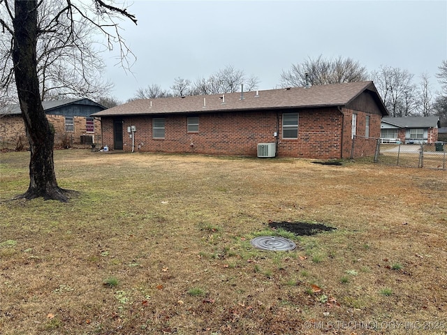 rear view of house featuring a yard and cooling unit