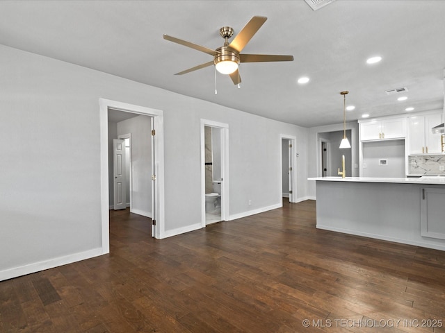 unfurnished living room featuring ceiling fan and dark hardwood / wood-style flooring