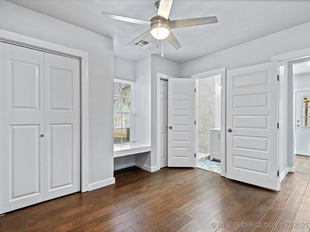 unfurnished bedroom with dark hardwood / wood-style floors, connected bathroom, and ceiling fan