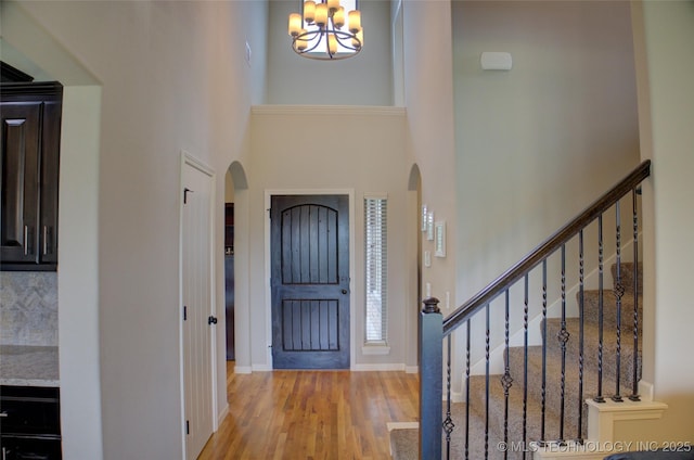 entryway with a high ceiling, a chandelier, and light hardwood / wood-style floors