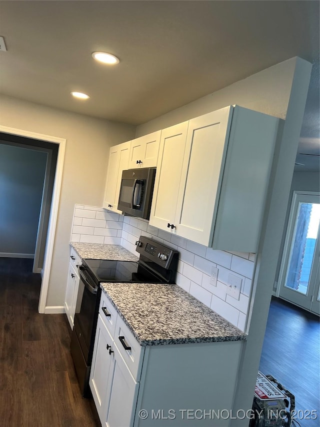 kitchen featuring white cabinetry, dark hardwood / wood-style floors, tasteful backsplash, and black appliances