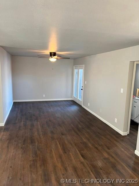 empty room featuring dark wood-type flooring and ceiling fan