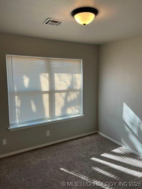 unfurnished room featuring dark carpet