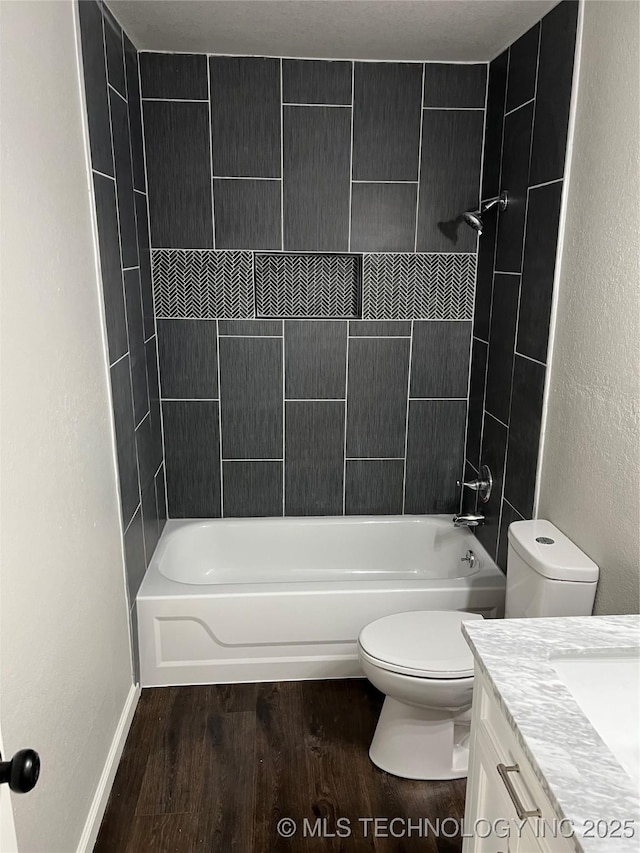 full bathroom with vanity, hardwood / wood-style floors, toilet, and tiled shower / bath