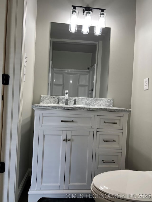 bathroom with vanity, toilet, and a shower