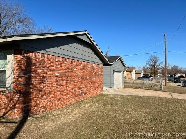 view of property exterior featuring a garage and a lawn