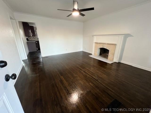 unfurnished living room featuring ceiling fan, ornamental molding, and dark hardwood / wood-style flooring