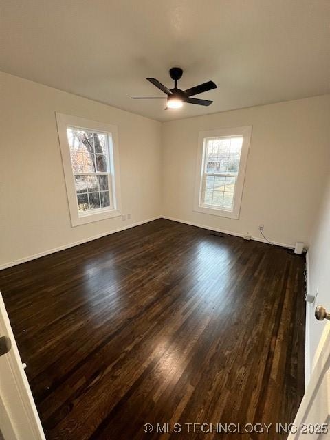 unfurnished room with dark wood-type flooring and ceiling fan