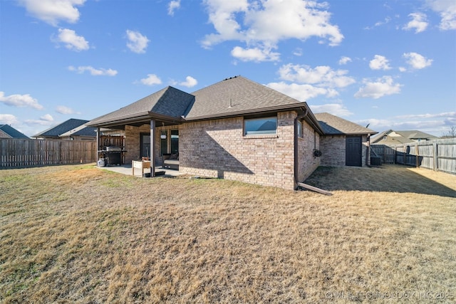 rear view of property with a lawn and a patio area