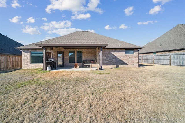 back of house with a patio and a lawn