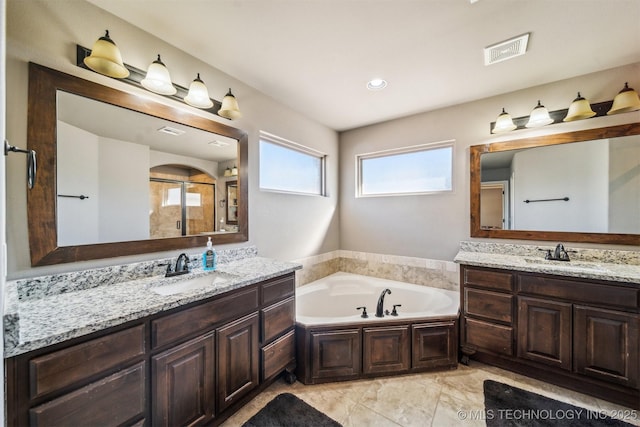 bathroom with vanity and shower with separate bathtub