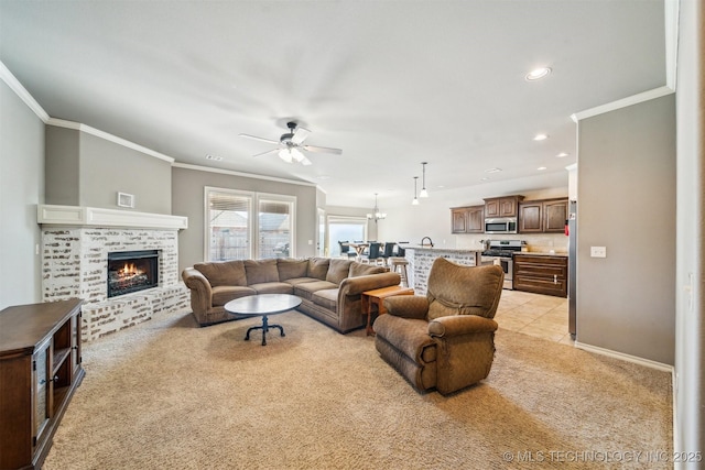 carpeted living room featuring a brick fireplace, crown molding, and ceiling fan