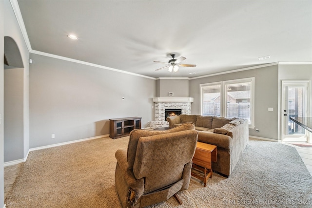 carpeted living room featuring a fireplace, ornamental molding, and ceiling fan