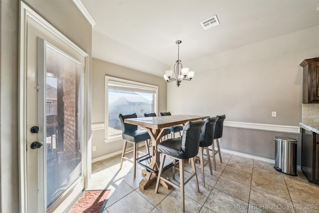 tiled dining room with a notable chandelier