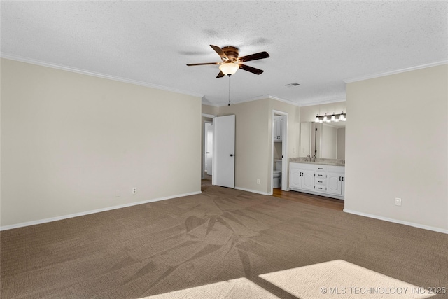 unfurnished bedroom with ensuite bath, ceiling fan, carpet floors, ornamental molding, and a textured ceiling