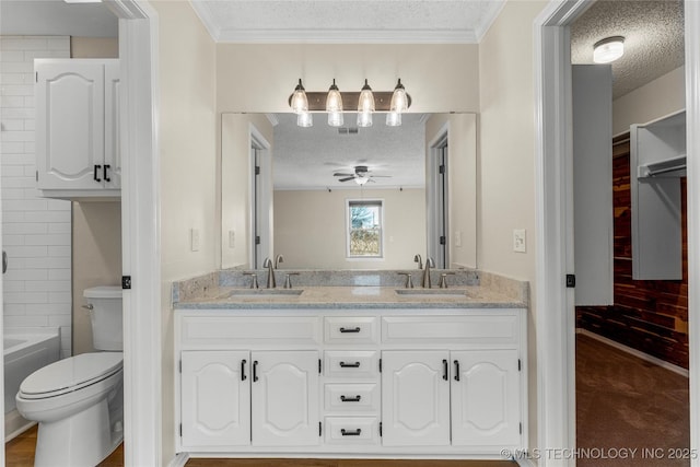 bathroom with ceiling fan, vanity, toilet, and a textured ceiling