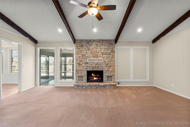 unfurnished living room with beam ceiling, carpet flooring, a fireplace, and a textured ceiling