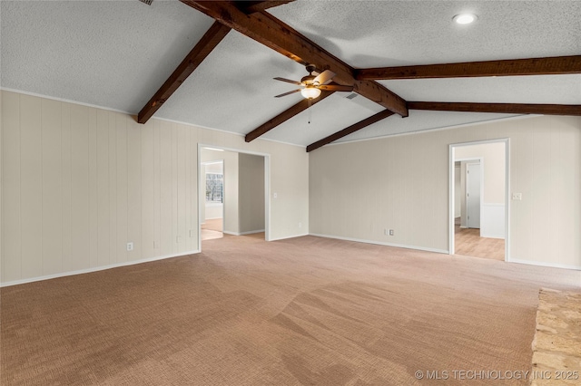 unfurnished living room featuring ceiling fan, light colored carpet, lofted ceiling with beams, and a textured ceiling