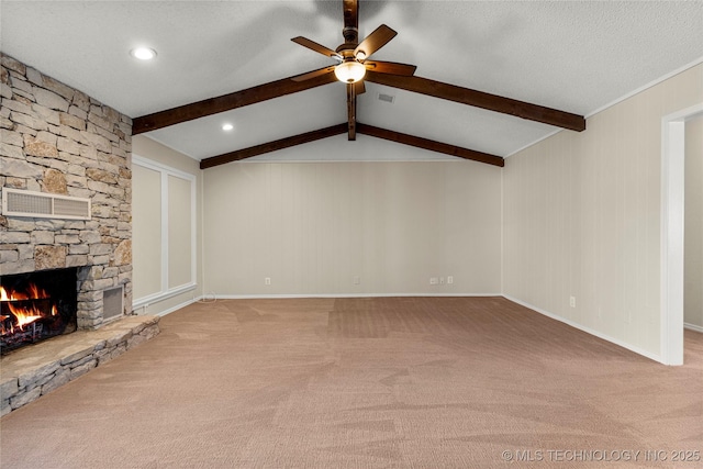 unfurnished living room featuring ceiling fan, carpet flooring, a stone fireplace, and a textured ceiling