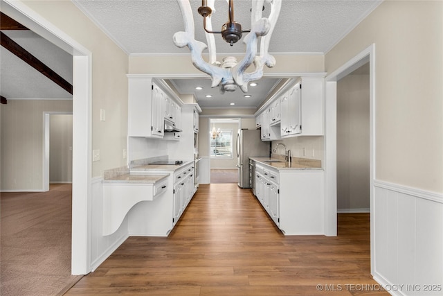 kitchen featuring ornamental molding, sink, white cabinets, and a textured ceiling