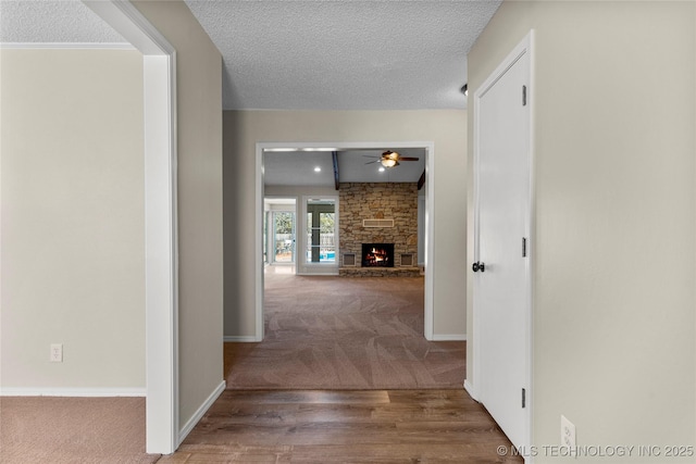 hallway with carpet and a textured ceiling