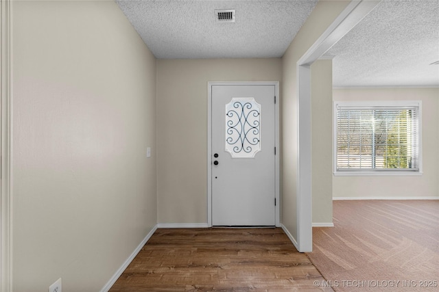 foyer entrance with a textured ceiling