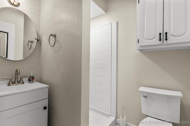 bathroom with walk in shower, vanity, and toilet