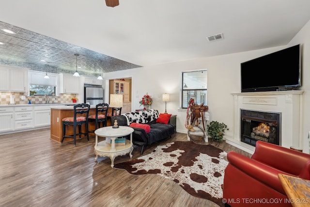 living room featuring sink and light hardwood / wood-style flooring