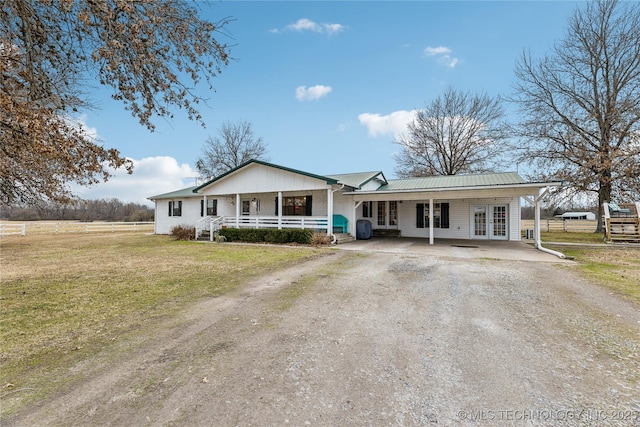 ranch-style house with a front lawn, covered porch, and french doors