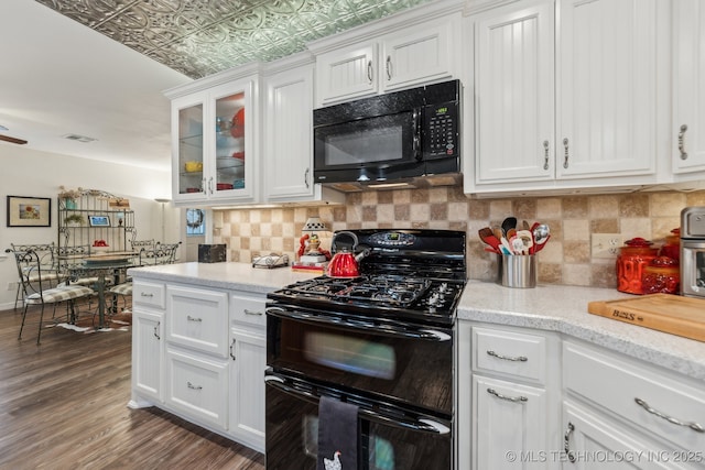 kitchen featuring dark wood-type flooring, white cabinets, decorative backsplash, and black appliances