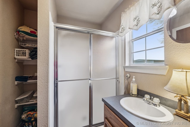 bathroom featuring walk in shower and vanity