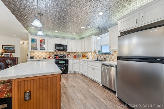 kitchen with white cabinets, sink, hanging light fixtures, and black appliances