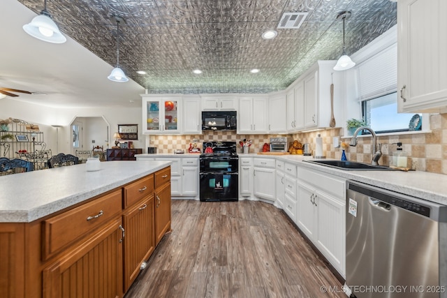 kitchen with pendant lighting, sink, white cabinetry, tasteful backsplash, and black appliances