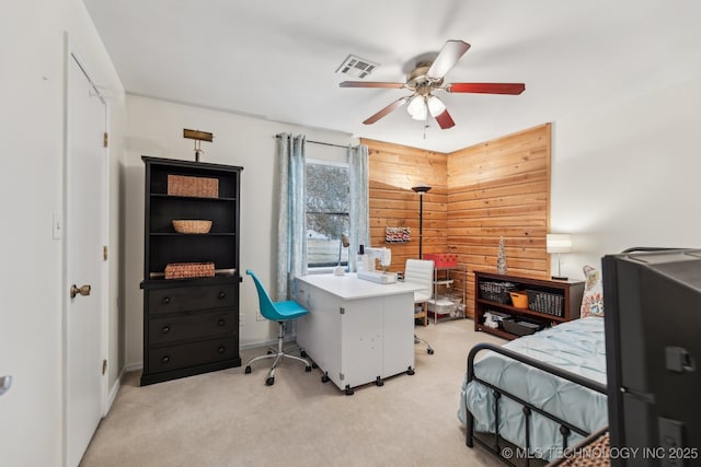 carpeted bedroom featuring ceiling fan and wood walls